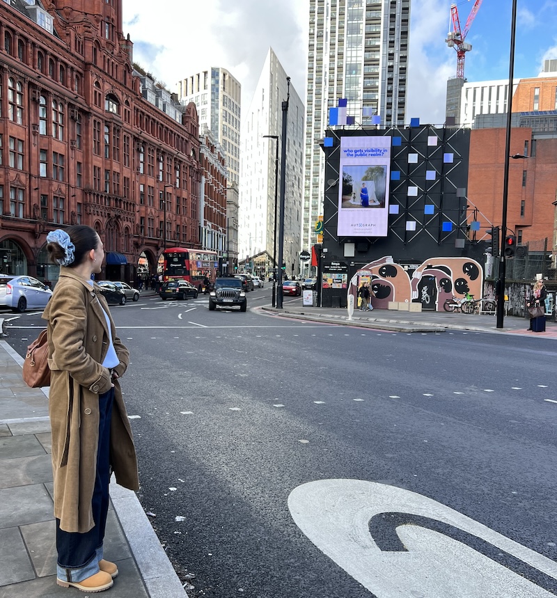 Olivia Cooper standing in front of the hoarding with her winning image at Old Street Olivia Cooper standing in front of the hoarding with her winning image at Old Street